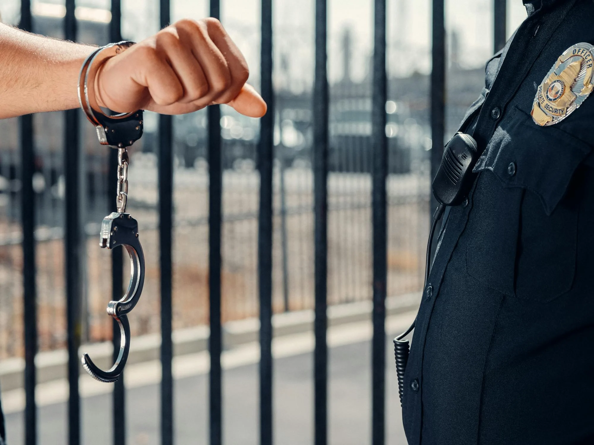 A law enforcement officer stands beside a handcuffed individual, highlighting the weight and responsibility of police work.